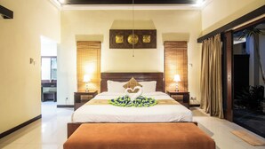 A hotel room with a large bed, a wooden bench, a wall-mounted artwork, and a view of the outside. - 5BR Private Pool Tiga Samudra Villa (2Units Villa) (badung)