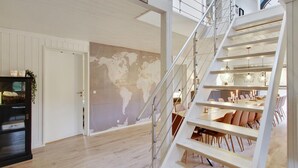 Ein modernes Interieur mit einer Wandmalerei einer Weltkarte, einer Treppe und einem Essbereich.