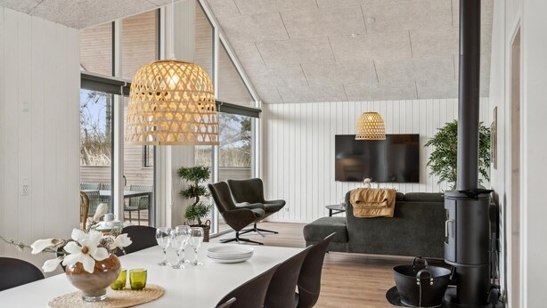 A modern living room with a dining area, large windows, a fireplace, and a television. - VillaVilla 648 - Hasmark Strand, Fyn og øer (Otterup)