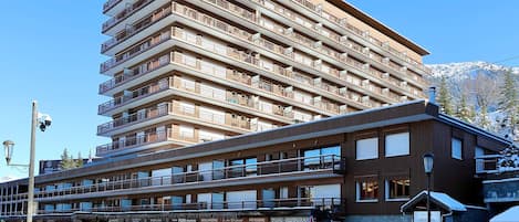 A multi-story hotel with balconies, a restaurant, and a parking area.