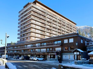 Ein mehrstöckiges Hotel mit Balkonen, einem Restaurant und einem Parkplatz.