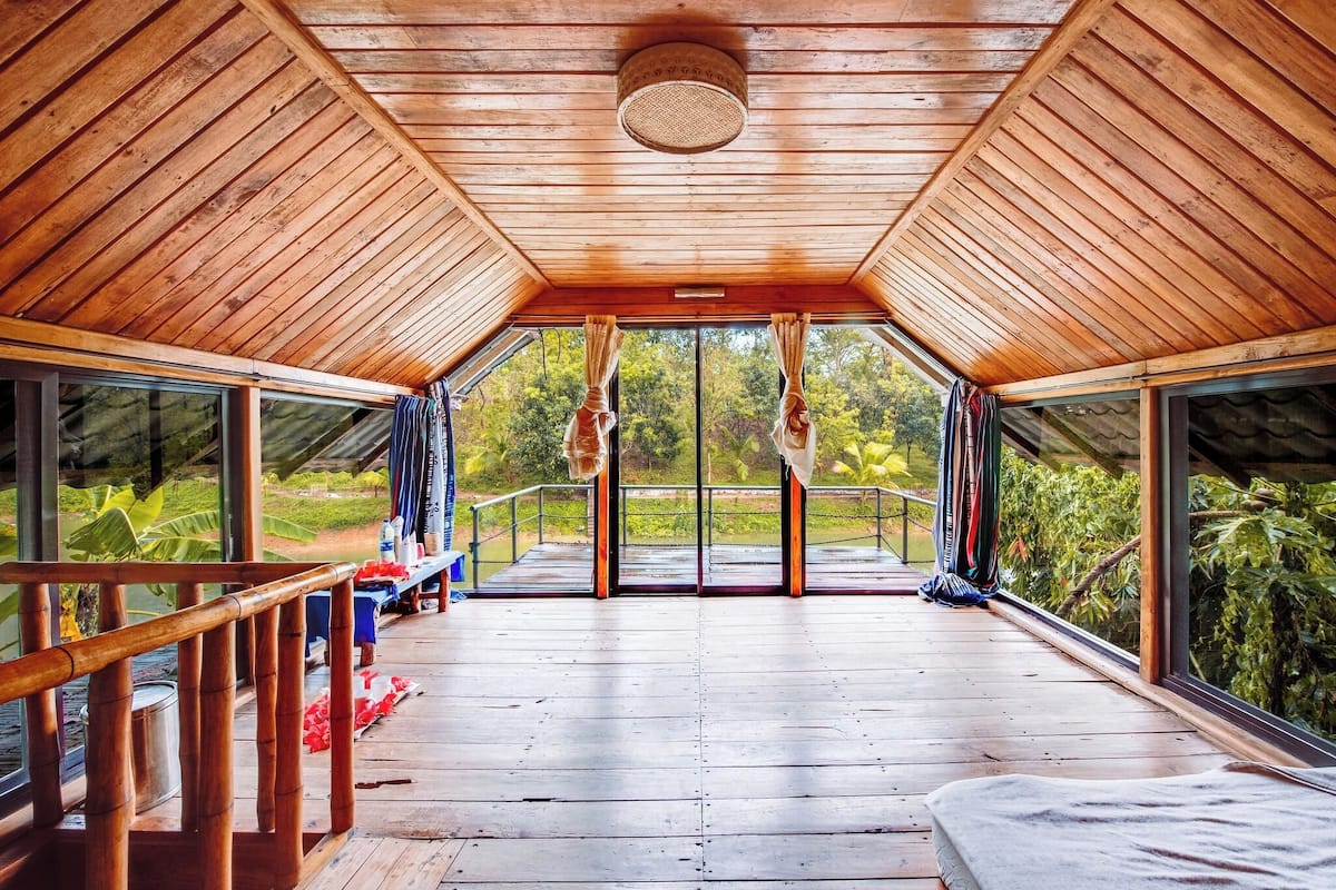 A wooden deck with a glass ceiling, offering a view of the surrounding greenery.