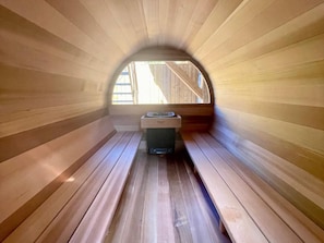 A sauna room with wooden walls and a bench.