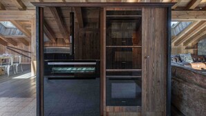 A modern interior with a wooden ceiling, built-in cabinetry, and a stone floor.