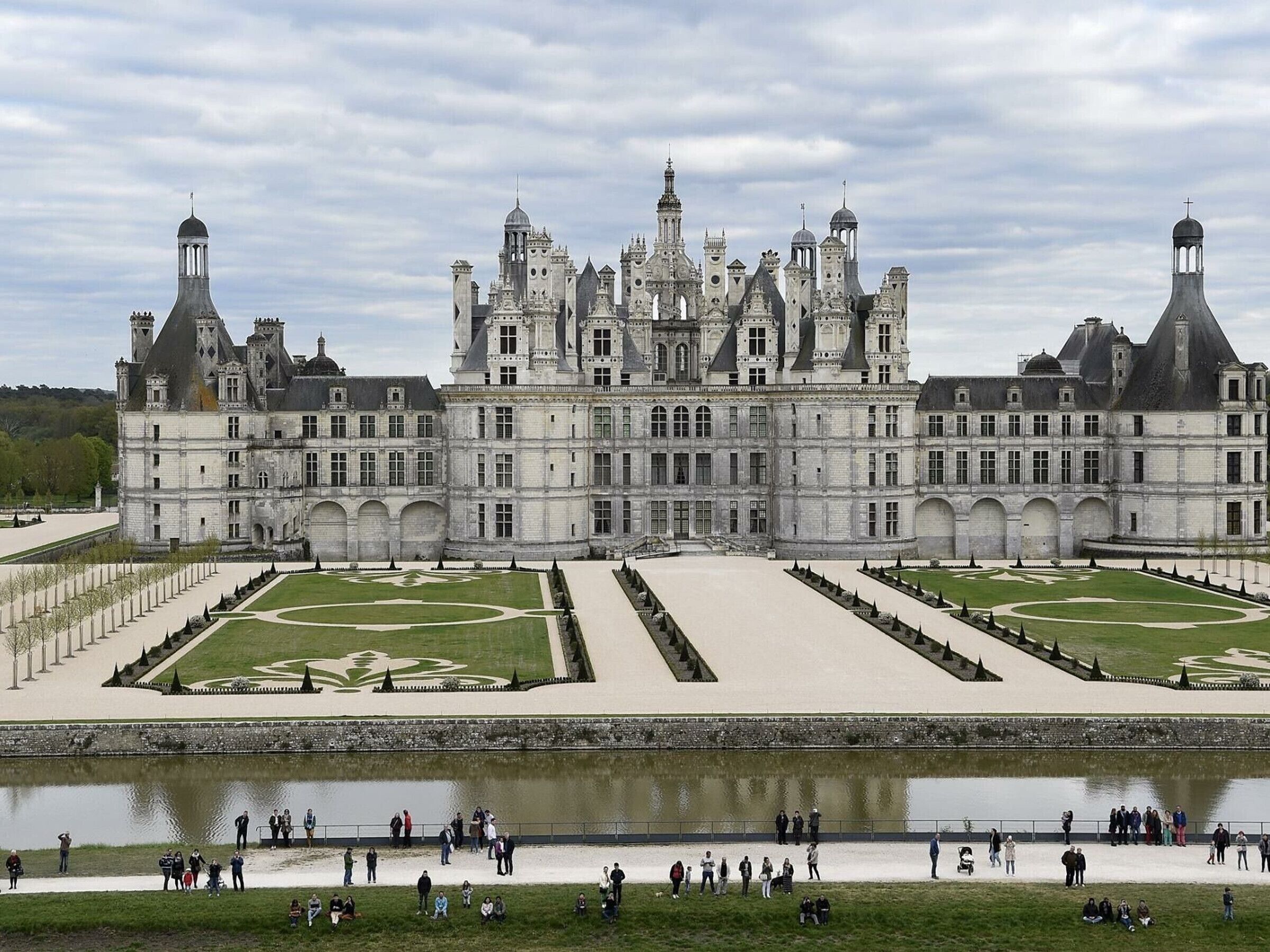 Un grand bâtiment historique doté de nombreuses tours et dont le jardin présente une disposition symétrique.