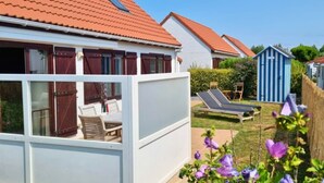 A residential area with a white house, red-tiled roof, and a blue shed. - Vacation home in De Haan - Beachhouse68 (De Haan)