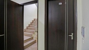 A hallway with two doors, one labeled 201, and a staircase leading to an upper floor. - Corporate Stayz (Gurugram)