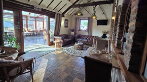 Um interior acolhedor com um sofá de couro, uma mesa de centro redonda e cadeiras de vime.