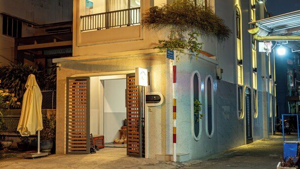 Un edificio de varios pisos con balcones, ventanas amplias y un acceso cubierto.