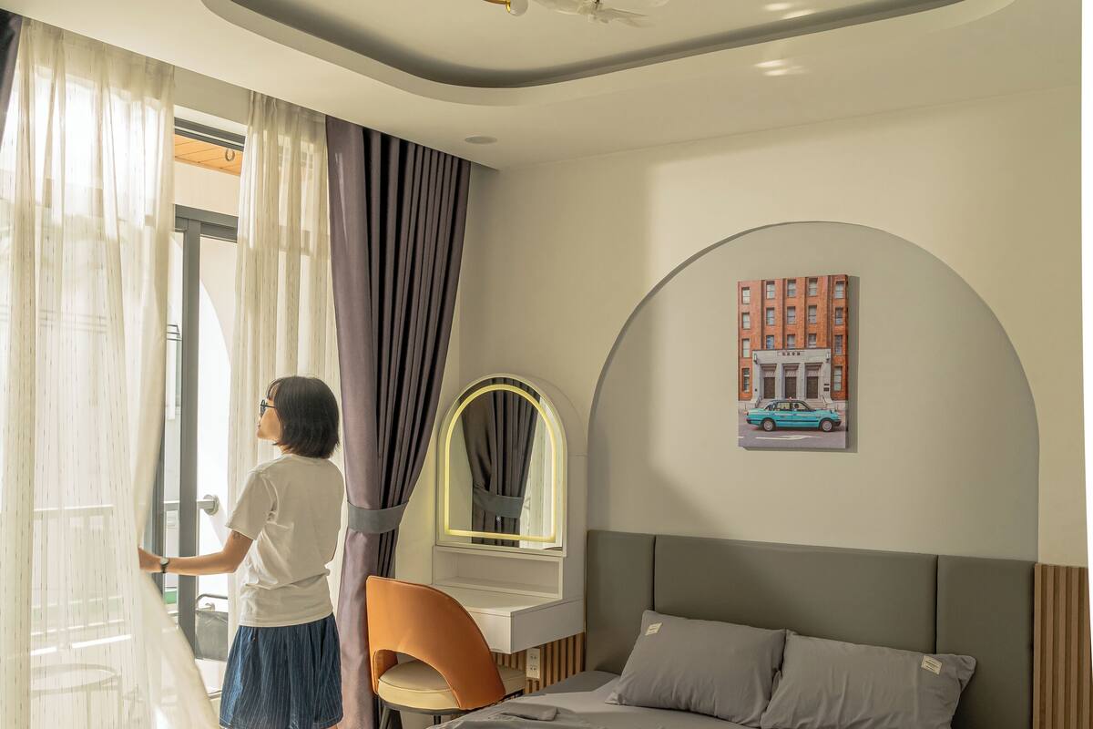 Une chambre moderne avec un lit, un bureau et une fenêtre avec des rideaux.