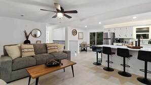A modern living room with a grey sofa, wooden coffee table, and a ceiling fan. - War Eagle Haven, Lake Access, spacious deck, games (Springdale)
