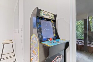 Une borne d’arcade rétro au design coloré, dotée d’un joystick et d’un écran affichant un jeu.