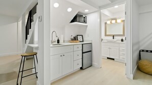 A modern kitchen with white cabinetry, a stainless steel refrigerator, and a built-in microwave. - War Eagle Haven, Lake Access, spacious deck, games (Springdale)