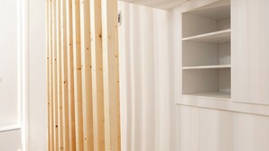 A room with a wooden partition, a built-in shelf unit, and a staircase. - Hidden History - Modern Split-Level (Tbilisi)