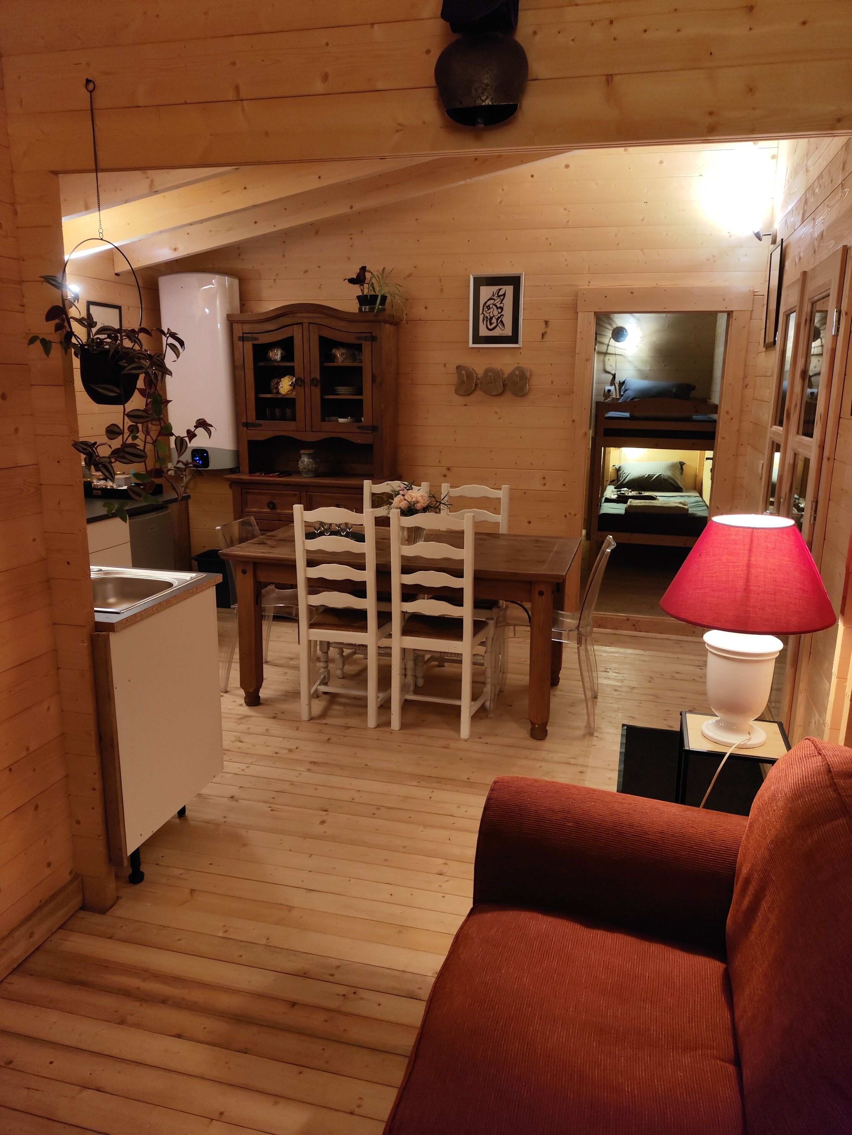 Een gezellig cabin interieur met een eethoek, keuken en een stapelbed.