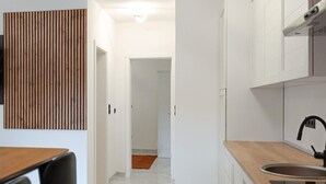 A modern kitchen with white cabinets, a wooden countertop, and a sink. - Beautiful apartment in Seline with WiFi (Seline)