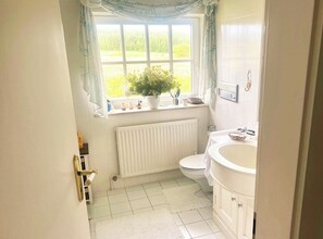 Een douche, handdoeken, zeep, toiletpapier