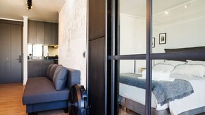 Ein modernes Schlafzimmer mit einem Bett, einer Couch und einem Ventilator.