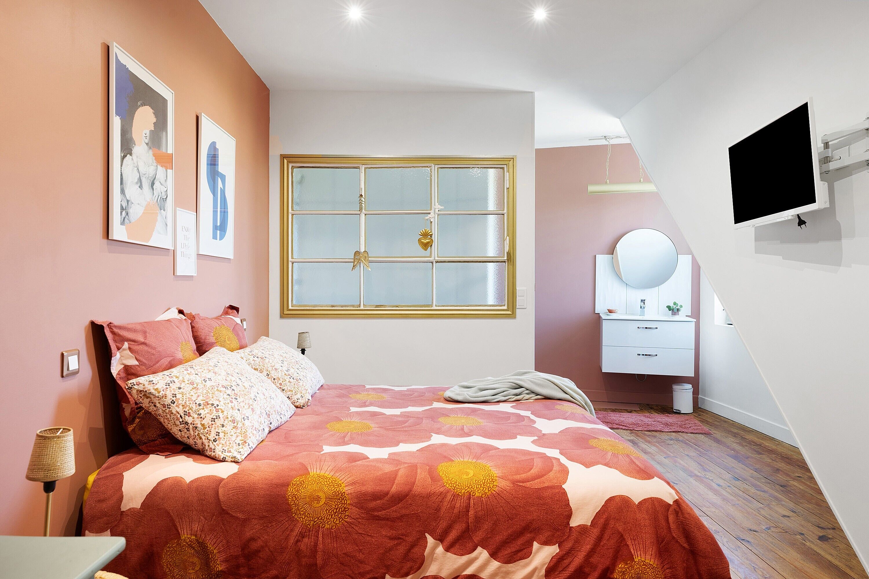 Ein Schlafzimmer mit einem Bett, einem Schminktisch, einem Spiegel und einem Fenster.
