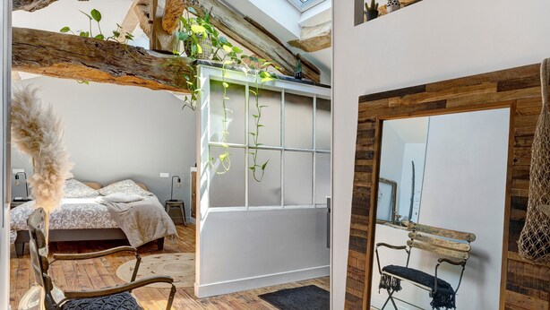 A bedroom with a bed, a white wardrobe, a wooden bench, and a hanging plant. - Bed and Breakfast 'Pampa' with Shared Terrace, Shared Garden and Wi-Fi (Riom)