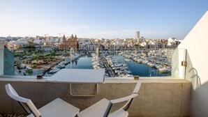 A terrace with a view of a marina and cityscape.