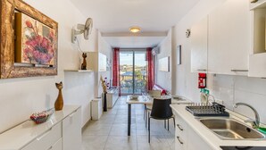 Uma cozinha moderna com área de refeições, vista para o exterior e uma pequena mesa com cadeiras.