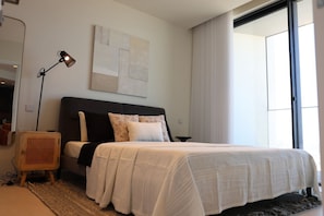 A modern bedroom with a large bed, a standing lamp, and a large window. - The Mercury Suite with pool (San Ġiljan)