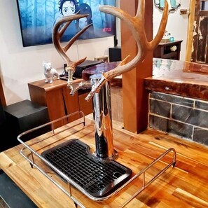 Eine Bar mit einem Metallhocker, einem Grill aus Metall und einem dekorativen Geweih.