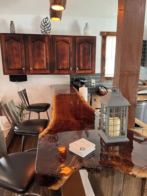 A kitchen with wooden cabinets, a dining table with chairs, and a unique wooden island.