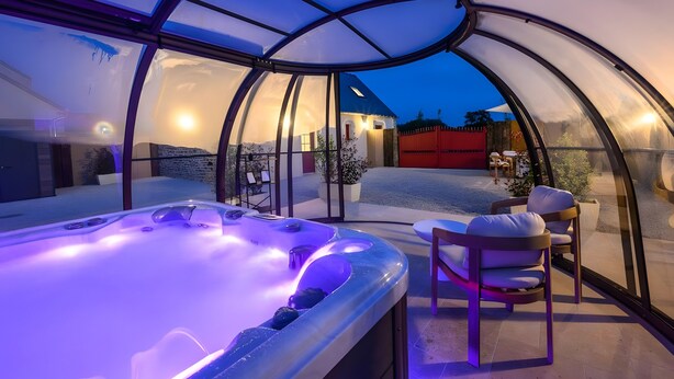 A hot tub inside a glass-enclosed structure with a view of the outside. - Holiday Home 'L'Ascalon' with Private Jacuzzi under Glass Dome, Wi-Fi & Air Conditioning (Saint-Sauveur-le-Vicomte)