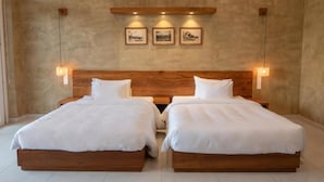 Ein Doppelzimmer mit zwei Betten, einem Holz-Kopfteil und Wandleuchten.