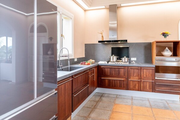 Een moderne keuken met houten kastjes, een roestvrijstalen afzuigkap en een inbouwoven.