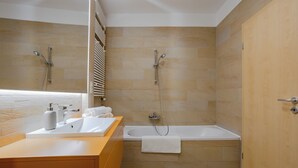 Un baño moderno con bañera, lavamanos y ducha.
