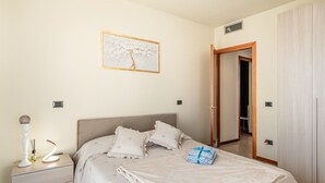 Une chambre à coucher avec un lit, une table de chevet, une lampe et un tableau au mur.