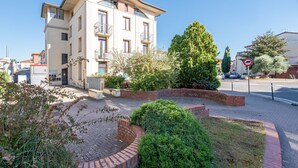 Un immeuble à plusieurs étages doté de balcons, d’une cour pavée et d’un panneau indiquant qu’il est interdit de se garer.