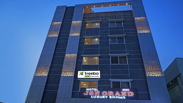 A multi-story building with a sign for 'Treebo JSN Grand Luxury Rooms'. - HOTEL JSN GRAND (Vijayawada)
