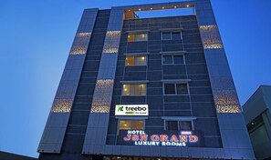 A multi-story building with a sign for 'Treebo JSN Grand Luxury Rooms'. - HOTEL JSN GRAND (Vijayawada)