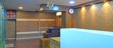 A reception area with a reception desk, seating area, and a wall-mounted clock.