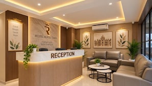 Zona de recepción de hotel con mostrador, área de estar y obras de arte en las paredes.