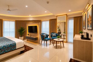 A modern hotel room with a large bed, a TV, a seating area with chairs, a small table, and a coffee machine. - Hotel Royal Time (Ahmedabad)