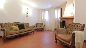 A living room with a sofa, armchairs, and a fireplace. - Villa Rosa Apartment (Borso del Grappa)
