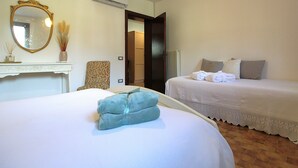 A hotel room with a bed, a chair, a mirror, and a radiator. - Villa Rosa Apartment (Borso del Grappa)