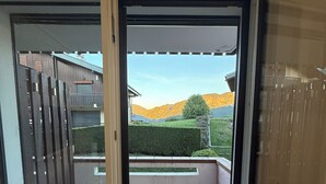 A balcony with a view of a mountain and a building in the background.