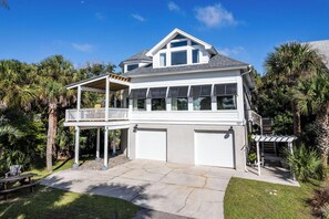 A two-story house with a balcony, a garage, and a well-maintained lawn. - 707 Silverside (Fripp Island)