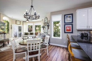 A spacious kitchen with a dining area, a chandelier, and large windows. - 707 Silverside (Fripp Island)