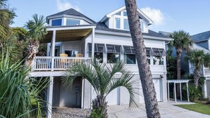 A two-story house with a balcony, a garage, and a well-maintained lawn.
