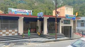 A building with multiple entrances, a staircase, and a flagpole. - Mandakini River View (Jakholi)