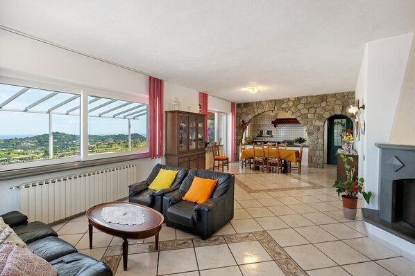 A spacious living area with a sofa, a dining table, and a fireplace.