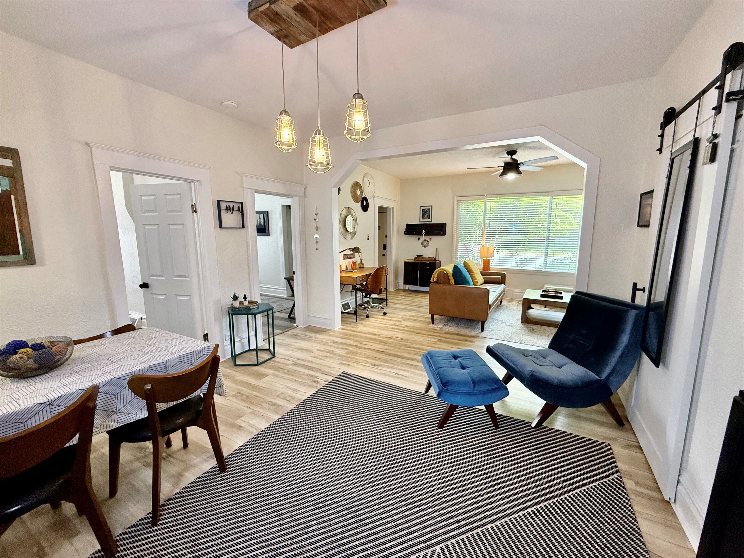 Un salón amplio con una mesa de comedor, sillas, un sofá y un sillón azul.