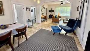 A spacious living area with a dining table, chairs, a sofa, and a blue armchair. - Wild Bird Grove – Paws Welcome, Near Downtown SLC (Salt Lake City)